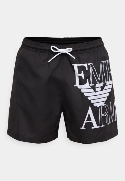 Črne kopalne kratke hlače iz gladkega materiala z belim tiskom logotipa in z zavezovanjem v pasu. Imajo tudi stranske zračnike na hlačnicah.