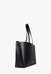 Borsa tote nera realizzata in materiale sintetico liscio. Presenta due manici lunghi e un design minimalista con cuciture sottili e un accento dorato.