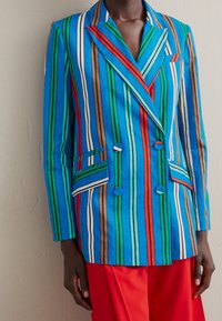 Double-breasted blazer in levendige blauw-, groen-, rood-, bruin- en witgestreepte kleuren. Heeft twee voorzakken en een contrasterende kraag.