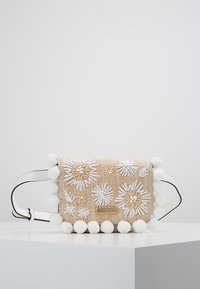 Borsa a tracolla beige intrecciata con ricami floreali bianchi e dettagli pom-pom. Presenta una tracolla bianca e una piccola placca con logo sul fronte.