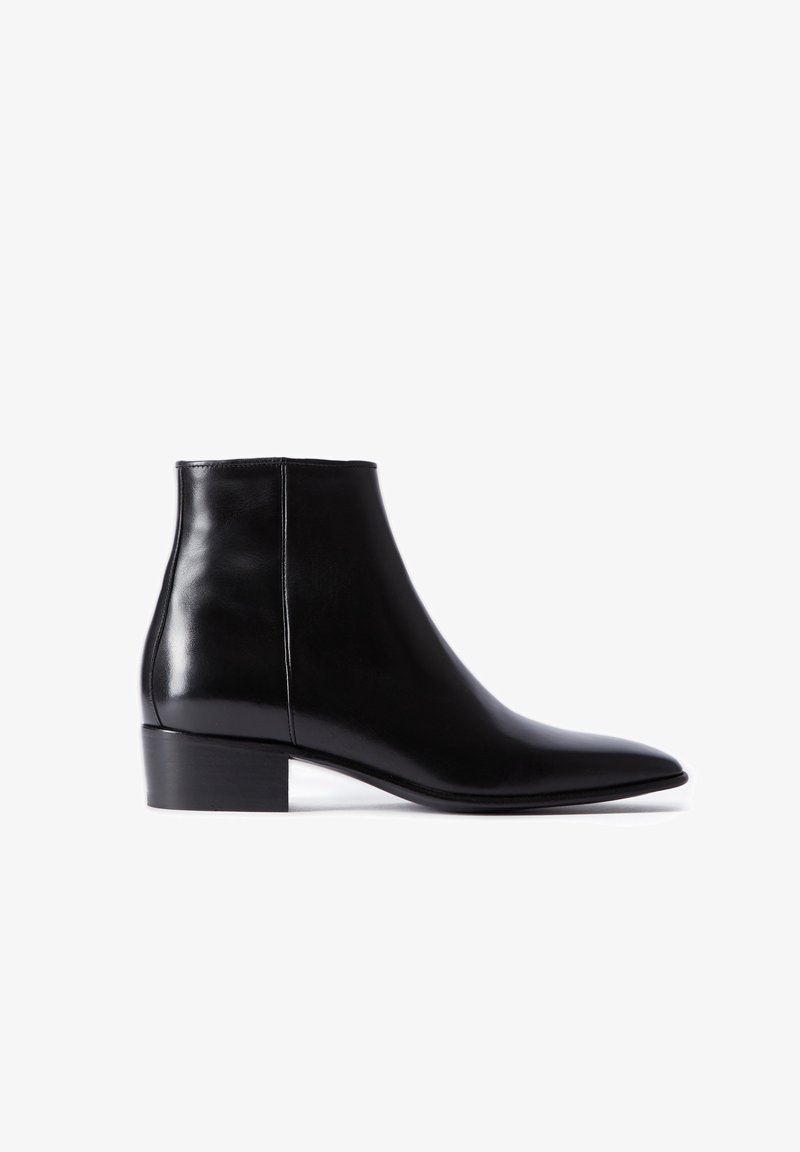 Bottine noire en cuir avec petit talon bloc et bout pointu, détail de couture latérale, vue de profil sur fond blanc.