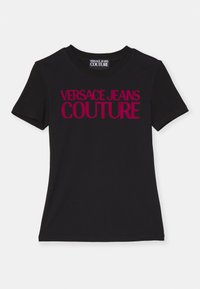 Svart T-skjorte med korte ermer, med stor magenta tekst "VERSACE JEANS COUTURE" over fronten, med en klassisk rund hals.