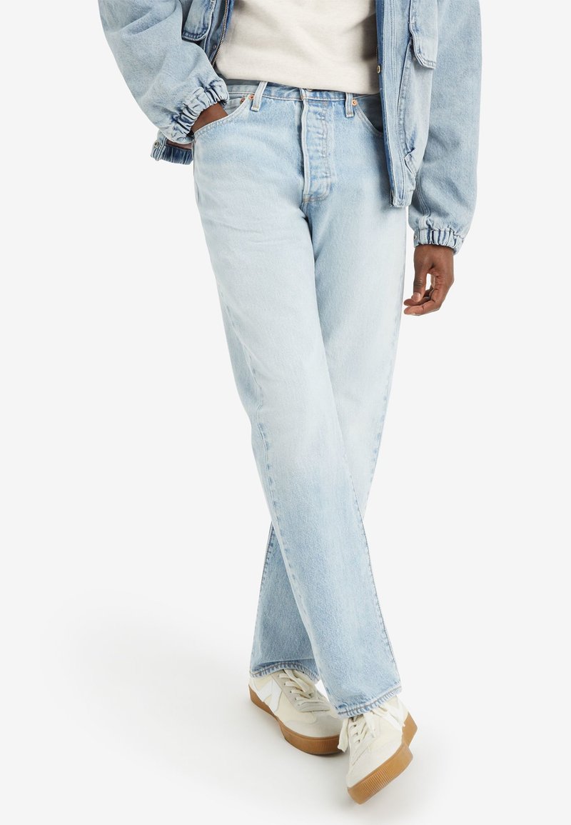 Lichtblauwe denim jeans met een rechte pasvorm, voorzien van een hoge taille en subtiele slijtage. Gekoeld met witte sneakers en een lichte jas.
