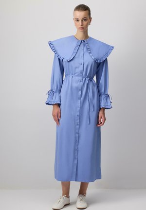 Vestito azzurro chiaro a maniche lunghe con un ampio collarino arricciato, chiusura frontale con bottoni, vita legata e polsini arricciati; tessuto dalla consistenza liscia.
