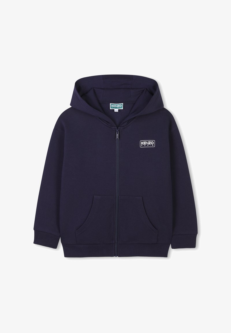 Hoodie zippé bleu marine avec une poche kangourou, des poignets côtelés et un patch logo sur la poitrine gauche ; fabriqué en matériau en coton texturé.