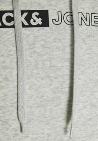 Világosszürke kapucnis pulóver texturált anyagból, fekete "BLACK & JONES" logónyomattal és összeillő húzózsinórokkal a kapucnin.