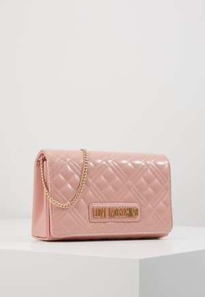 Sac en cuir matelassé rose avec bandoulière chaîne dorée et plaque dorée "LOVE MOSCHINO" à l’avant, posé sur une surface blanche.