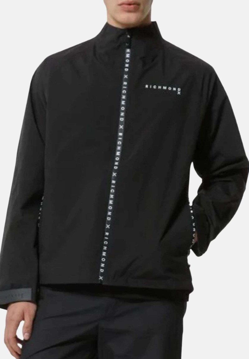 Giacca impermeabile nera con colletto alto, dotata di zip frontale e branding bianco "RICHMOND" lungo il centro e le maniche.
