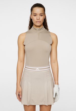 Abito da golf senza maniche beige con collare alto, chiusura con zip, gonna plissettata a fantasia e fascia in vita con strisce bianche. Accompagnato da un guanto da golf bianco.