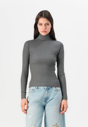 Grå stripete genser med høy hals og lange ermer, sammen med lyseblå slitte jeans med avslappet passform og klassisk fem-lommers design.