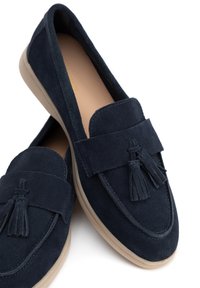 Námořnické semišové slip-on boty s plochou podrážkou. Mají dekorativní detail s třásněmi a kontrastní světlou podrážku. Kulatá špička.