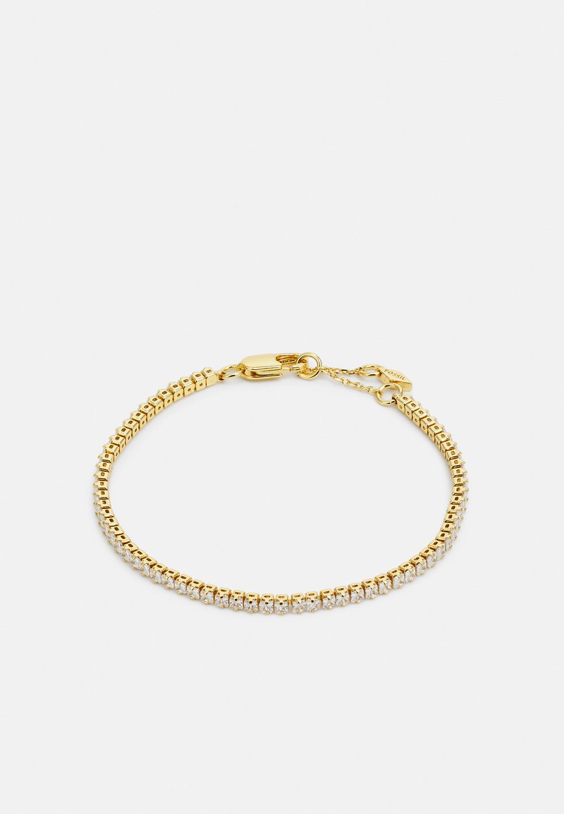 Guldtonet armbånd med et fleksibelt design med kvadratiske led. Den ene side er prydet med klare krystaller. Inkluderer en sikker lås.