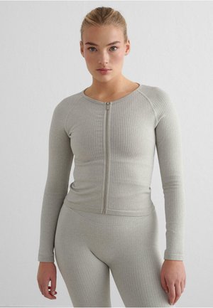 Lys grå, rillet langermet topp med glidelås, med rund hals og tettsittende design, kombinert med matchende rillet tights.