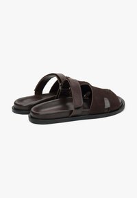 Dark brown sandals made of leather and suede, featuring an open-toe design, adjustable straps, and a flat rubber sole.