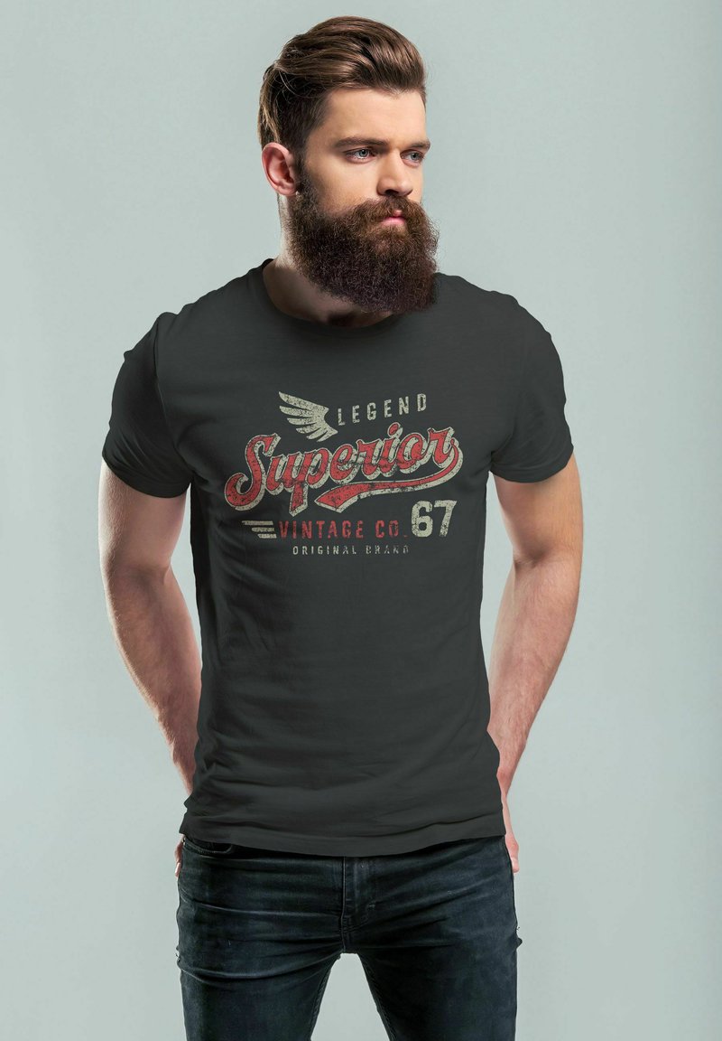 Schwarzes T-Shirt mit einem Vintage-Druck, der "Legend Superior Vintage Co. 67" in Rot, Creme und Grau zeigt. Enges Design, kurze Ärmel.