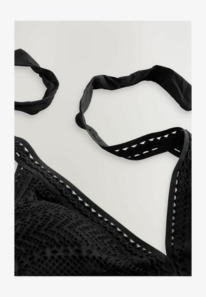Schwarzer Spitzen-Bralette mit texturiertem Muster, ausgestattet mit schwarzen Satin-Trägern und dekorativen Ausschnitten entlang der Kanten. Weiche Stoffoberfläche.