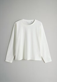 Balta garām piedurknēm krekls, kas izgatavots no mīkstas auduma, ar apaļu kakla izgriezumu un taisnu piegriezumu, bez redzamām rakstiem vai rotājumiem.