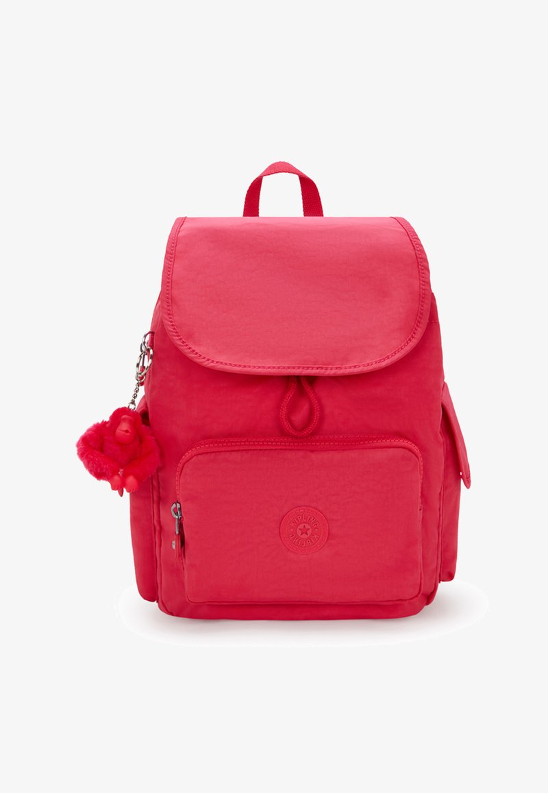 Mochila de nylon rosa con cierre de solapa, bolsillo frontal con cremallera, acabado texturizado y un suave charm de pom-pom adjunto a la cremallera.