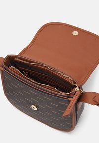 Brown leather crossbody bag with a patterned dark exterior, gold hardware, and multiple compartmentalized sections inside. Zipper closure.