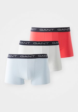 Trois paires de boxers en bleu clair, blanc et corail avec une ceinture élastique noire arborant le logo GANT. Matière en coton lisse.