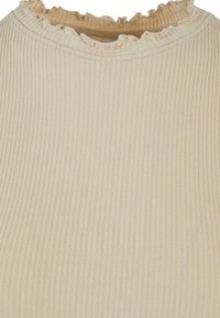 Tissu côtelé beige avec une délicate bordure en forme de laitue le long de l'encolure ronde d'un vêtement.