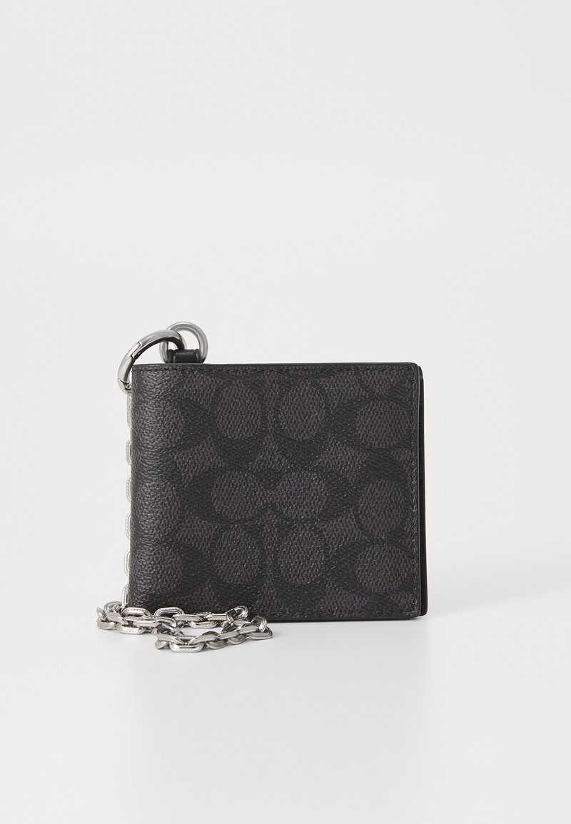 Portefeuille noir texturé avec un motif en relief, doté d'une chaîne en métal attachée à un anneau pour le transport. Forme rectangulaire compacte.