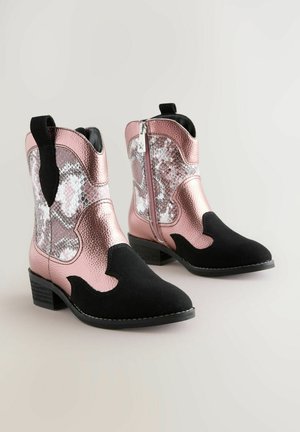 Rózsaszín, textúrált szintetikus cowboy csizmák fekete részletekkel, amelyek kígyóbőr mintával, oldalsó cipzárral és alacsony blokk sarkúak.