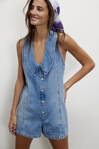 Ολόσωμη φόρμα από τζιν με βαθύ ντεκολτέ σε σχήμα V, υπερμεγέθη γιακά, κλείσιμο με κουμπιά μπροστά και ανοιχτό γαλάζιο ξεβάμωμα με άνετη εφαρμογή.