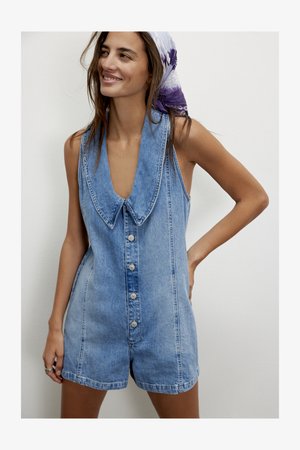 Farmer anyagú overál mély V-nyakkivágással, nagyobb gallérral, elöl gombos záródással és világoskék színű, laza szabással.