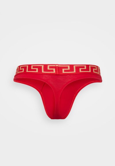 Roter Baumwoll-Tanga mit einem goldenen geometrischen Muster am Bund. Glatte Textur und minimales Design für eine reduzierte Bedeckung. Helle Farbe verbessert die Sichtbarkeit.