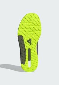 Athletikschuhsohle in leuchtendem Neon-Gelb mit strukturierten Mustern, versehen mit grauen Akzenten und einem "DUAL DENSITY"-Etikett für zusätzlichen Halt.
