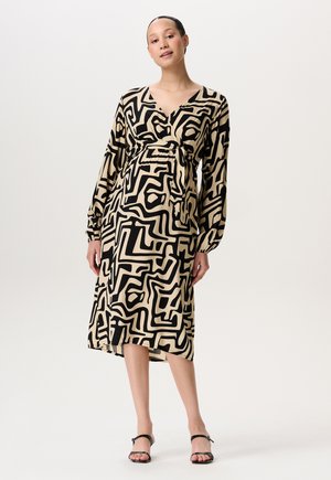 Zwarte en beige gedrukte jurk met lange mouwen, diepe v-hals, getailleerde taille en asymmetrische zoom, met abstracte geometrische patronen.