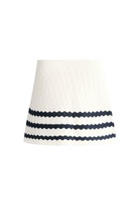 Mini-jupe blanche en maille avec trois bandes horizontales noires ondulées près de l'ourlet et une ceinture côtelée.