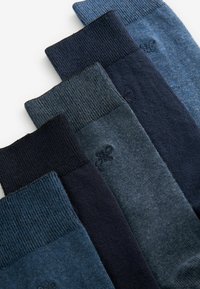 Baumwollmischsocken in dunklen Blau- und Marine-Tönen mit gerippten Bündchen und subtilen Strukturvariationen, nebeneinander angeordnet.