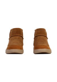 Bottes ankle en daim tan avec un bout rond, deux sangles décoratives sur le devant et une semelle en caoutchouc blanc. Texture lisse avec un minimum de détails.