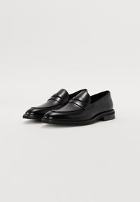 Loafers din piele neagră cu un finisaj neted, având vârful rotunjit și o bandă decorativă în partea de sus. Toc mic și stivuit.