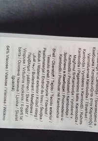 Étiquette affichant les instructions d'entretien et la composition du matériau, y compris "64% Viscose" et un texte multilingue sur les types de tissus et leurs utilisations.
