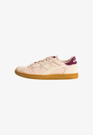 Sneaker beige dal profilo basso con suola in gomma, logo laterale testurizzato, stringhe beige e linguetta sul tallone bordeaux con marchio bianco.