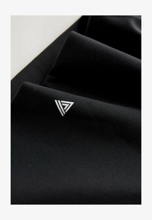 Musta kangas, jossa on sileä pinta ja hopeinen kolmionmuotoinen logo alakulmassa. Kangas on taitettu.