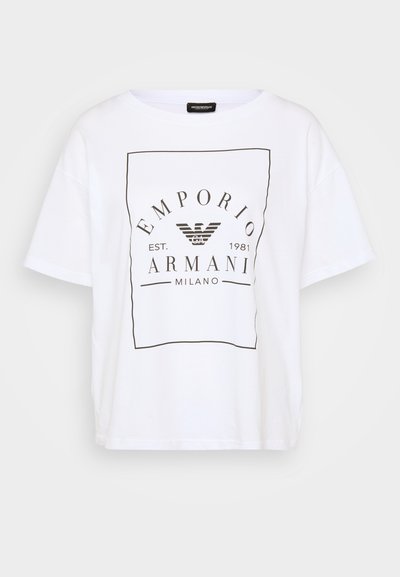 Hvid bomulds t-shirt med en løs pasform, rund halsudskæring og korte ærmer. Har et sort grafisk logo og tekst i midten.