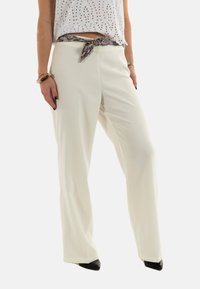 Pantaloni bianchi plissettati con un design a gamba larga, dotati di una cintura in stile serpente con texture. Tessuto morbido e silhouette fluida.