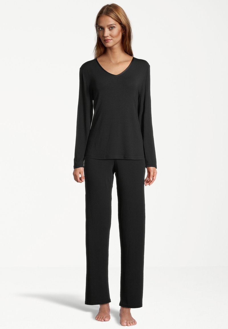 Schwarzes Langarm-V-Ausschnitt-Oberteil, kombiniert mit passenden weit geschnittenen Hosen, aus weichem Stoff mit glatter Textur und minimalen Nähten.