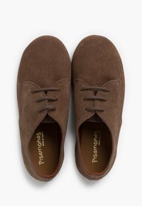 Le scarpe in pelle scamosciata marrone presentano una punta rotonda, dettagli di cucitura discreti e un classico design con lacci. All'interno, è visibile un rivestimento rosso a contrasto.