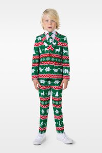 Zaļš uzvalks ar sarkaniem un baltiem svētku motīviem, tostarp briežiem un sniegpārslām. Apvienots ar baltu kreklu un rakstainu kaklasaiti, kā arī baltiem sporta apaviem.