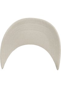 Beige baseballpet met een gebogen klep, gemaakt van een textuurstof, met zichtbare stiksels langs de randen en een glad, flexibel ontwerp.