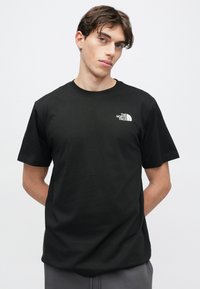 Μαύρο βαμβακερό t-shirt με κοντά μανίκια και στρογγυλή λαιμόκοψη. Διαθέτει μικρό λευκό λογότυπο στο αριστερό στήθος. Λεία υφή, κανονική εφαρμογή.