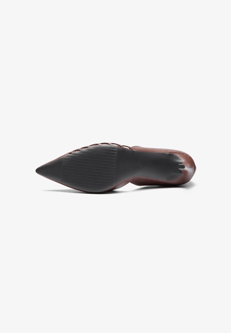 Zapato de tacón alto marrón con punta afilada, con parte superior de cuero texturizado y suela de goma negra lisa que presenta un leve patrón de agarre.