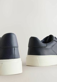 Tumedat meresneakerid tekstuuritud nahast, valge kummitaldaga. Omavad sujuvat varba disaini ja peeneid õmblusdetailsid.