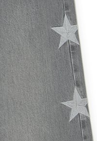 Gray denim joggers with light gray embroidered stars on the side. Features include a smooth texture and a tapered shape.