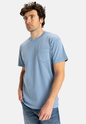 Lys blå t-shirt lavet af blødt bomuld, med en rund hals og en lomme på venstre bryst. Korte ærmer og en afslappet pasform.